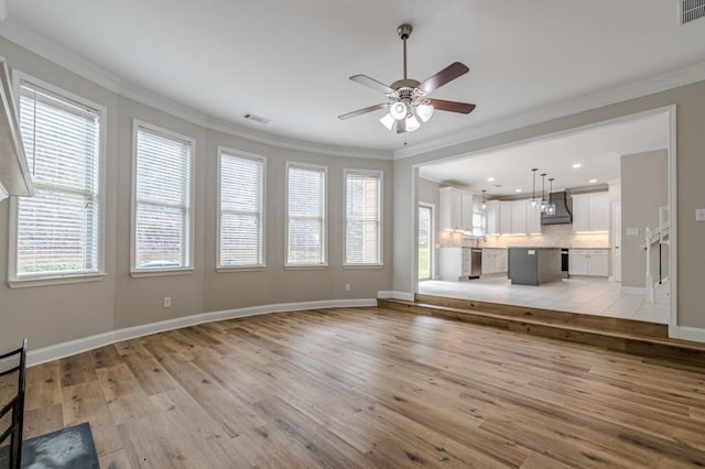 unfurnished living room featuring ceiling fan, light wood-type flooring, and crown molding