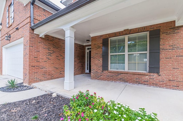 doorway to property with covered porch and a garage