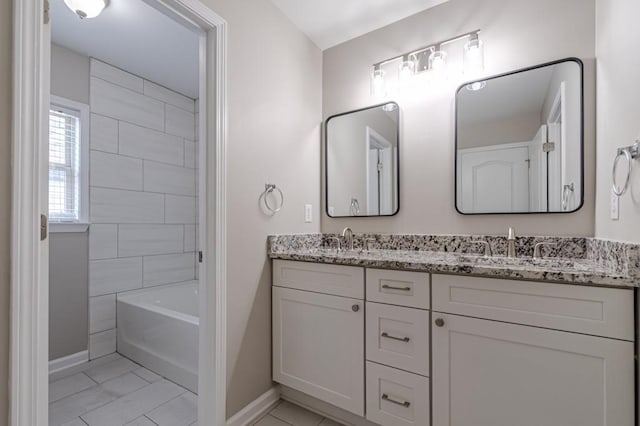 bathroom with tile patterned flooring, vanity, and a washtub