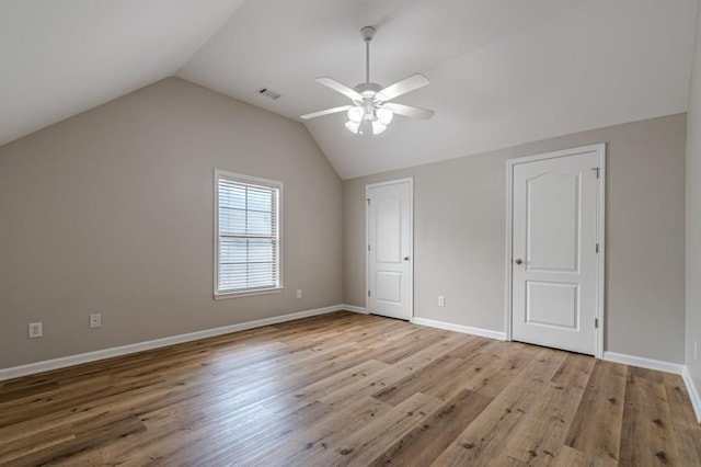 unfurnished bedroom featuring ceiling fan, light wood-type flooring, and vaulted ceiling