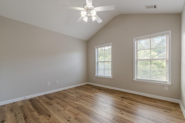 spare room featuring ceiling fan, light wood-type flooring, and lofted ceiling