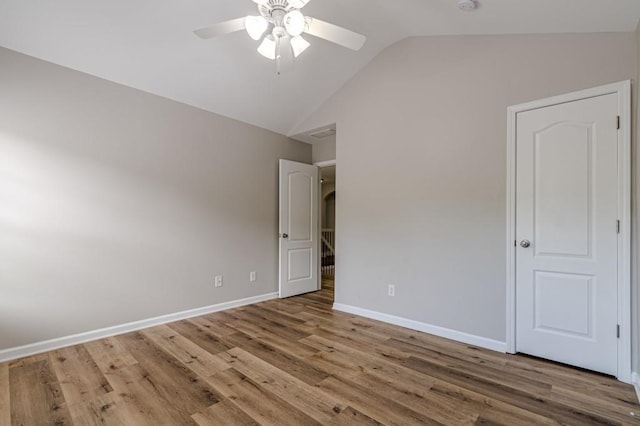 unfurnished bedroom with wood-type flooring, lofted ceiling, and ceiling fan