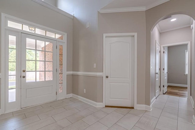 entryway with crown molding and light tile patterned floors