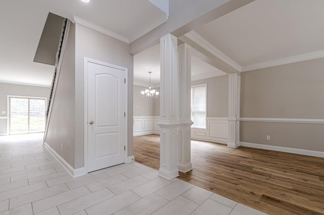 interior space with a notable chandelier, light hardwood / wood-style floors, plenty of natural light, and decorative columns