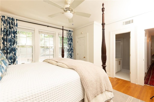 bedroom featuring baseboards, visible vents, light wood-style floors, ceiling fan, and crown molding