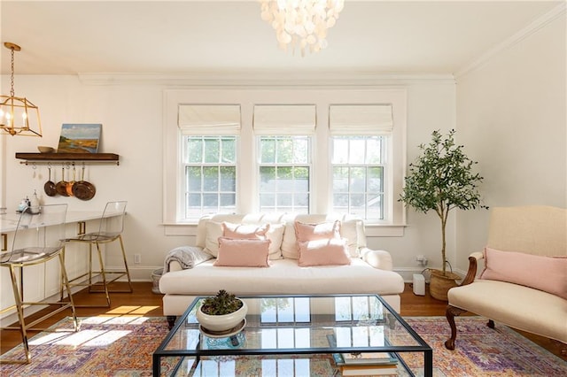 sitting room with baseboards, wood finished floors, a notable chandelier, and crown molding