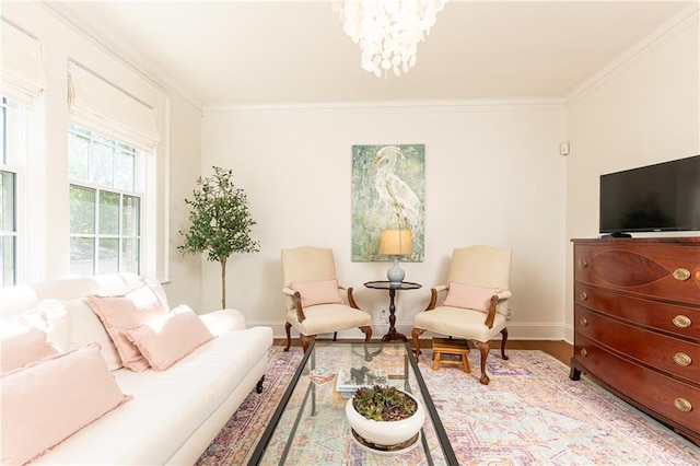 sitting room with a chandelier, wood finished floors, baseboards, and ornamental molding