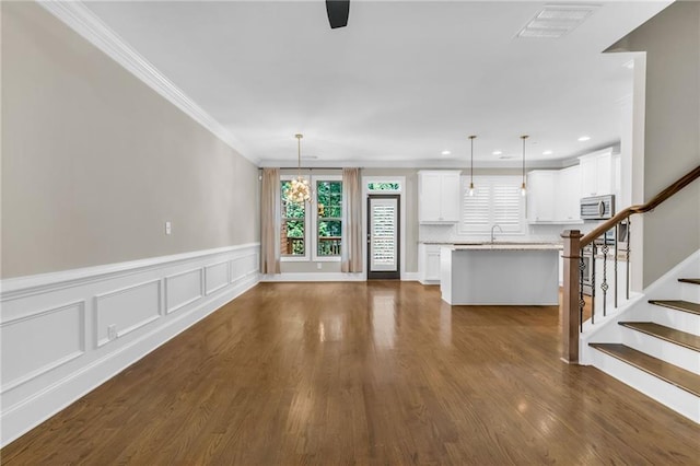 1547 Cambridge Pl, Marietta, GA 30062 - unfurnished living room with plenty of natural light, ornamental molding, a wainscoted wall, dark wood-style floors, and stairway