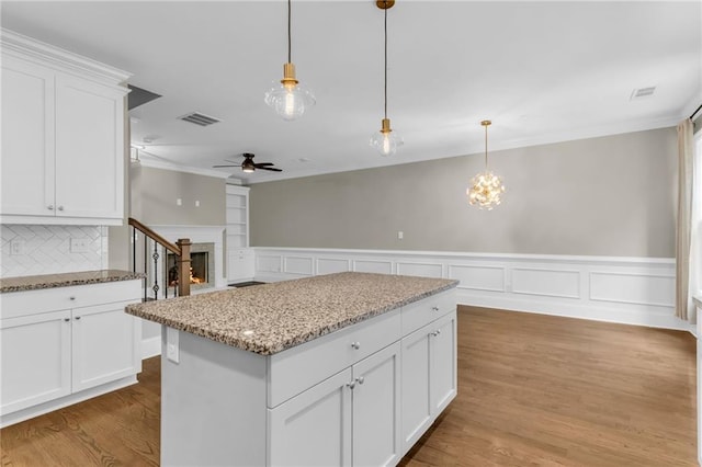 1547 Cambridge Pl, Marietta, GA 30062 - kitchen featuring a ceiling fan, white cabinets, a kitchen island, crown molding, and decorative light fixtures