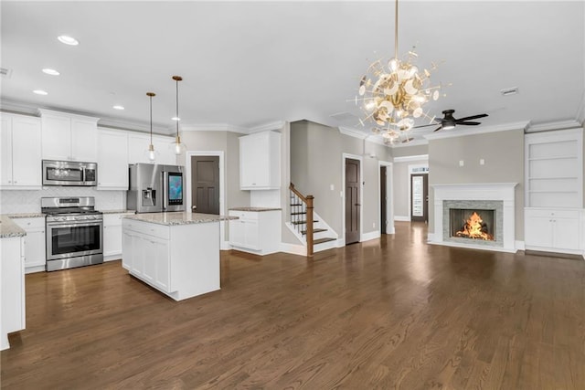 1547 Cambridge Pl, Marietta, GA 30062 - kitchen with stainless steel appliances, crown molding, recessed lighting, a ceiling fan, and a fireplace with flush hearth
