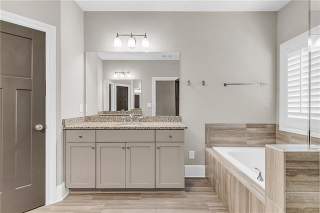 1547 Cambridge Pl, Marietta, GA 30062 - bathroom with a garden tub, vanity, wood finished floors, and baseboards