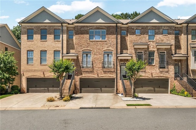 1547 Cambridge Pl, Marietta, GA 30062 - townhome / multi-family property featuring stairway, driveway, an attached garage, and brick siding