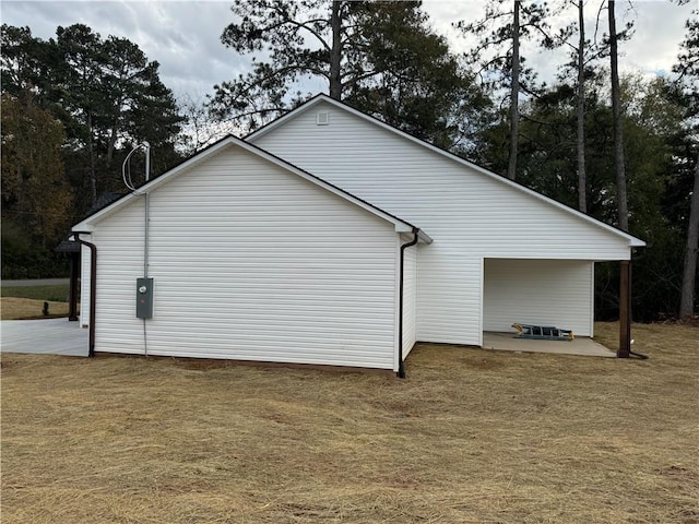 view of side of home featuring a yard and a patio