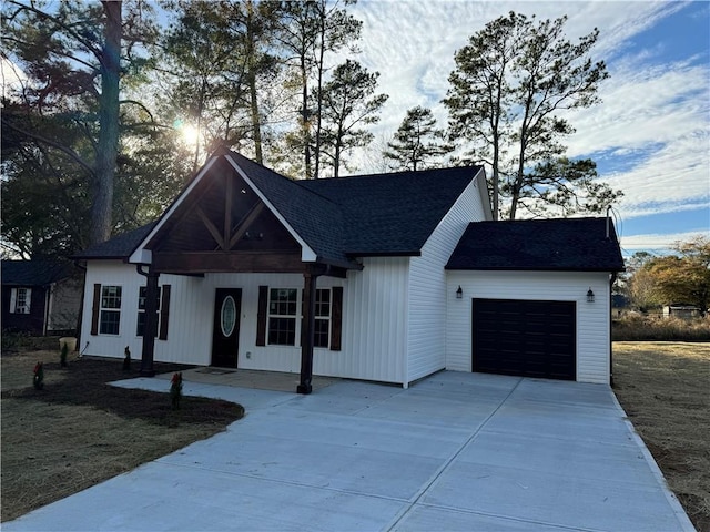 view of front of property featuring a porch, a garage, and a front lawn