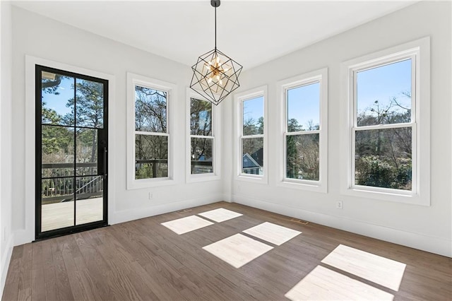 1857 Defoor Ave, Atlanta, GA 30318 - unfurnished sunroom featuring baseboards, wood finished floors, and a notable chandelier