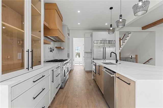 1857 Defoor Ave, Atlanta, GA 30318 - kitchen with custom exhaust hood, a spacious island, a sink, light wood finished floors, and premium appliances