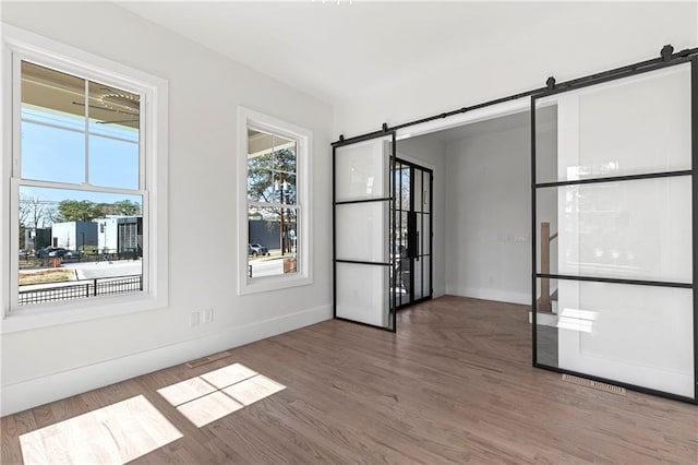 1857 Defoor Ave, Atlanta, GA 30318 - empty room featuring baseboards, a barn door, and wood finished floors