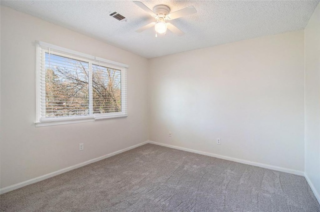 empty room with a textured ceiling, a ceiling fan, baseboards, and carpet floors