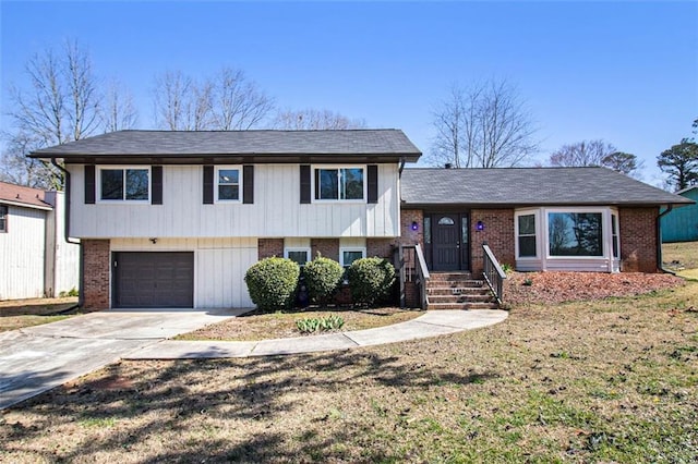 split level home with brick siding, an attached garage, and driveway