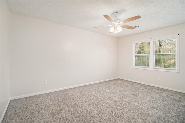 spare room with carpet flooring, a ceiling fan, baseboards, and a textured ceiling