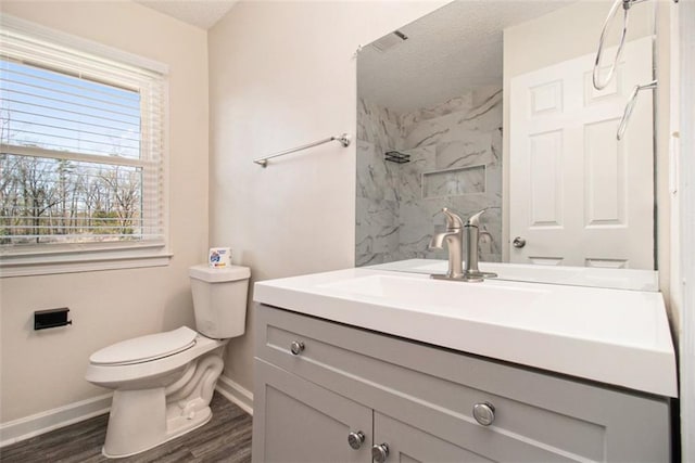 bathroom with vanity, toilet, a walk in shower, and a textured ceiling