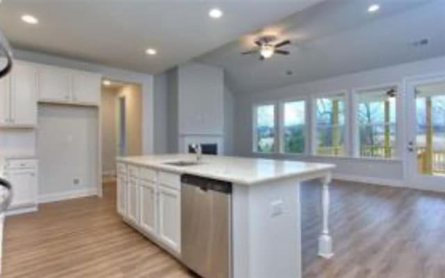 kitchen featuring a ceiling fan, white cabinetry, vaulted ceiling, baseboards, and dishwasher