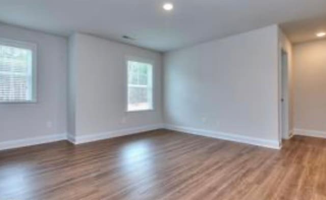 unfurnished room featuring recessed lighting, wood finished floors, and baseboards