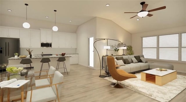 living area with light wood finished floors, a ceiling fan, lofted ceiling, and baseboards