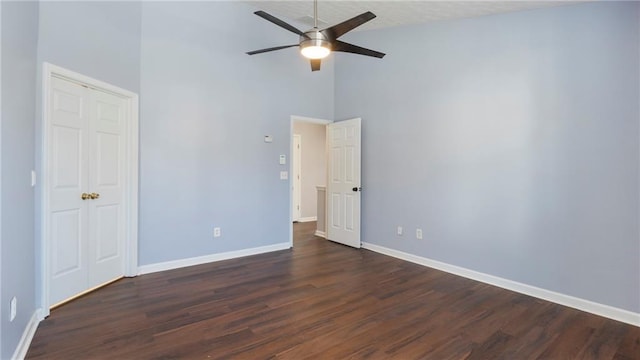 unfurnished bedroom with ceiling fan, high vaulted ceiling, and dark hardwood / wood-style flooring