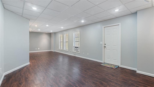 empty room featuring cooling unit, a paneled ceiling, and dark hardwood / wood-style floors