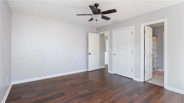 unfurnished bedroom with ceiling fan and dark hardwood / wood-style floors