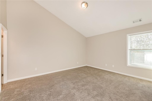 carpeted spare room with lofted ceiling