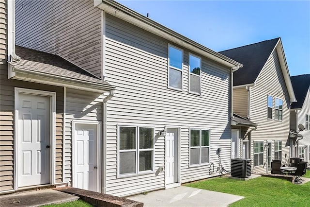 rear view of property with a yard and central AC unit