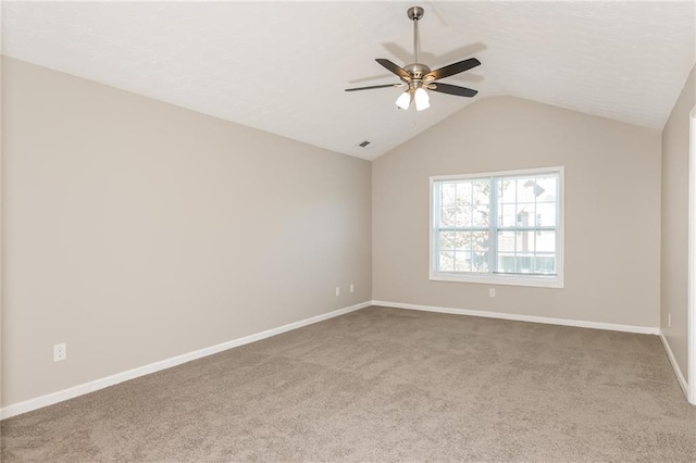 carpeted empty room featuring ceiling fan and vaulted ceiling