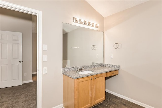 bathroom with hardwood / wood-style flooring, vanity, and vaulted ceiling