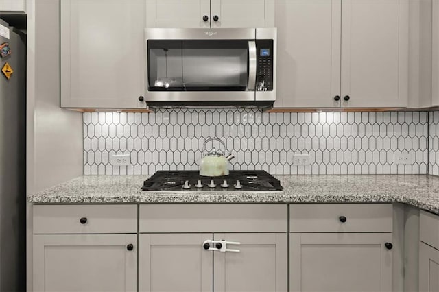 372 Garnet Dr, Acworth, GA 30101 - kitchen with appliances with stainless steel finishes, backsplash, and light stone counters
