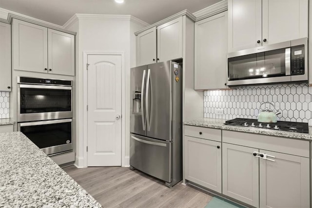 372 Garnet Dr, Acworth, GA 30101 - kitchen with appliances with stainless steel finishes, light wood-style flooring, decorative backsplash, gray cabinets, and ornamental molding