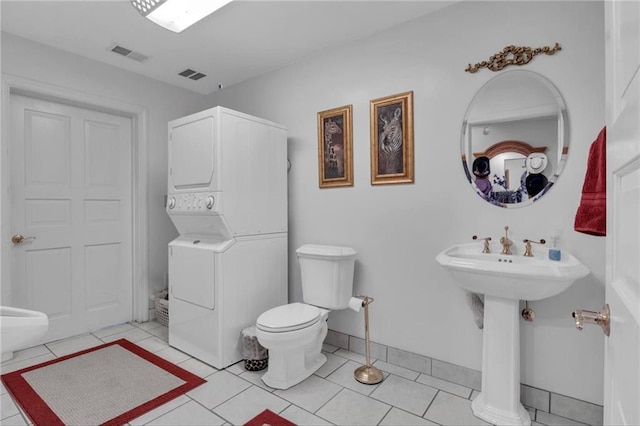 14501 Woolsey Rd, Hampton, GA 30228 - bathroom with estacked washer and dryer and tile patterned flooring