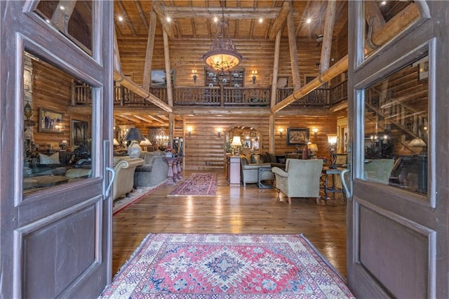 14501 Woolsey Rd, Hampton, GA 30228 - foyer featuring a high ceiling, log walls, wood-type flooring, a chandelier, and a wooden ceiling with exposed beams