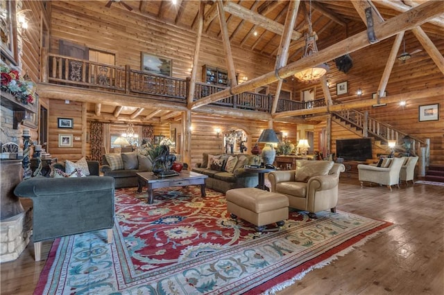 14501 Woolsey Rd, Hampton, GA 30228 - living area with high vaulted ceiling, a wooden ceiling with exposed beams, log walls, stairway, and wood-type flooring