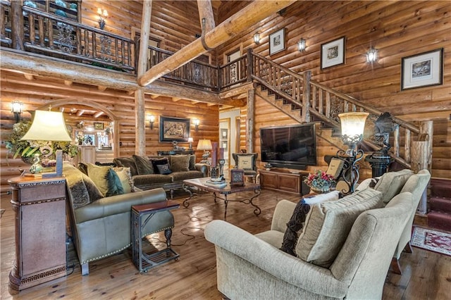 14501 Woolsey Rd, Hampton, GA 30228 - living area with a high ceiling, rustic walls, stairs, and hardwood / wood-style floors