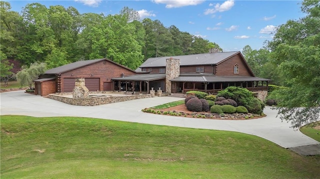 14501 Woolsey Rd, Hampton, GA 30228 - view of front of property featuring driveway, a front lawn, a garage, and a metal roof
