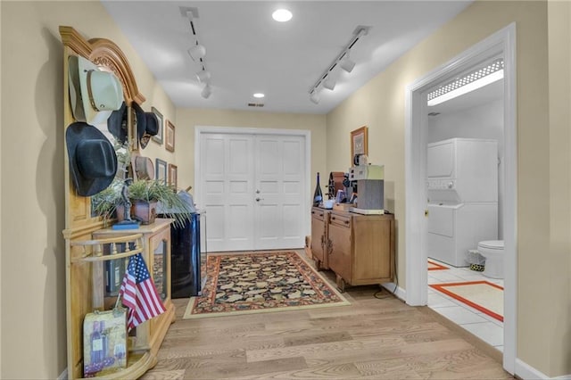 14501 Woolsey Rd, Hampton, GA 30228 - foyer with stacked washing machine and dryer, rail lighting, and light wood finished floors