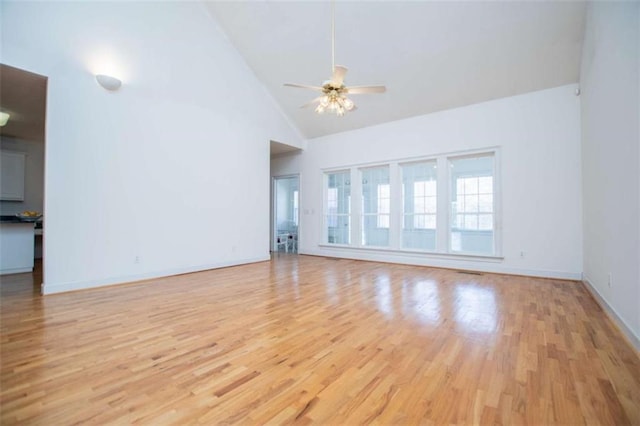 unfurnished living room featuring light wood-style floors, high vaulted ceiling, a ceiling fan, and baseboards