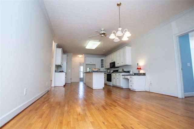 kitchen featuring range with gas stovetop, ornamental molding, open floor plan, a chandelier, and white cabinetry