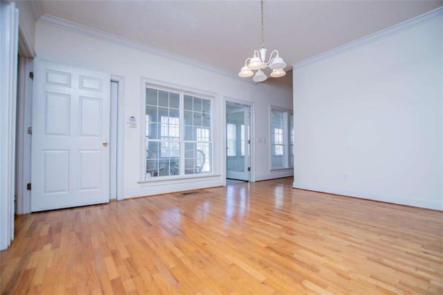 empty room featuring crown molding, a chandelier, light wood-style floors, and baseboards