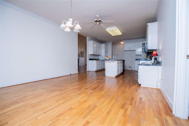 kitchen with open floor plan, dark countertops, light wood-style flooring, a chandelier, and a ceiling fan