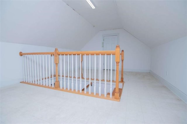 additional living space featuring lofted ceiling and baseboards