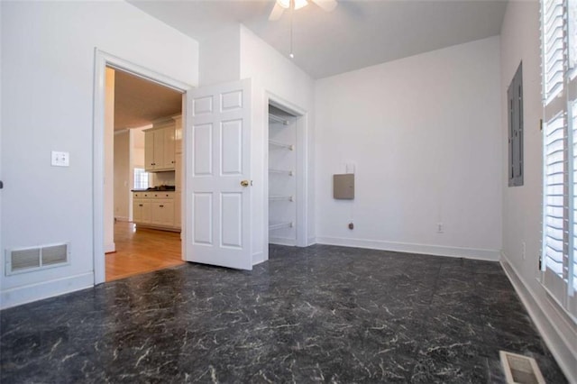 unfurnished bedroom featuring baseboards, electric panel, and ceiling fan