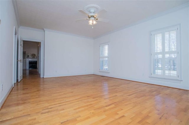 unfurnished room featuring crown molding, light wood-style floors, a ceiling fan, and baseboards